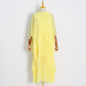 Détail d'une robe en mousseline jaune avec col montant et couches de volants étagées