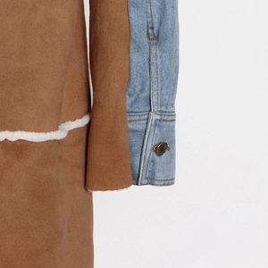 Dettaglio di patchwork in denim e pelle scamosciata con bordo in shearling e bottone