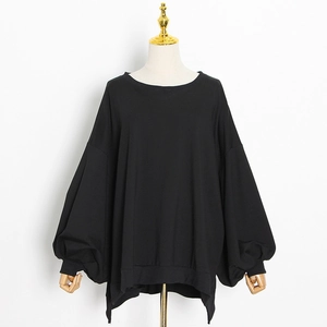 Close-up of black oversized pullover featuring dramatic puff sleeves and ribbed cuffs