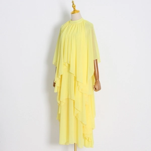 Détail de la robe en mousseline jaune avec des volants et des manches cape élégantes