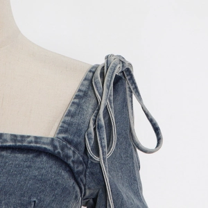 Detail shot of navy blue washed denim top with thick shoulder ties and twill texture
