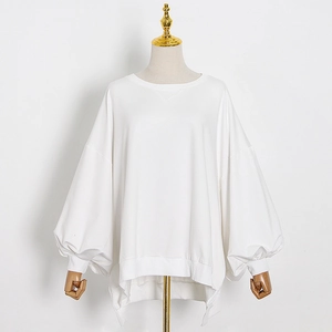 Close-up of white oversized crewneck sweatshirt with puff sleeves and side split hem