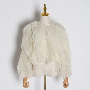 Detailed view of layered organza ruffles on an off-white French style blouse cardigan
