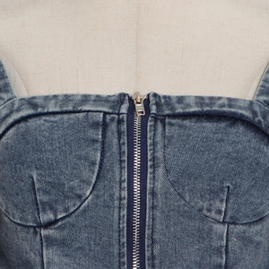 Detail of blue denim tube top featuring a front metal zipper and washed texture