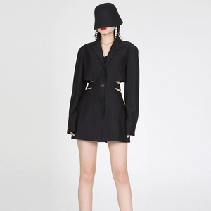 Detail van zwarte blazer met zij-uitsparingen en getailleerde eenknoops-sluiting
