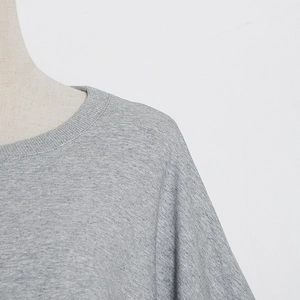 Detail of grey heather fabric with ribbed crew neck and smooth stitching on sweatshirt