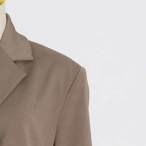 Detailed macro view of the lapel and shoulder seams on a brown twill blazer jacket