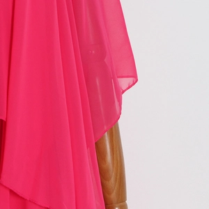 Détail du tissu en mousseline fuchsia avec volants élégants et couches irrégulières