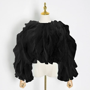 Detail of black tiered ruffle blouse showing textured pleats and lantern sleeve design