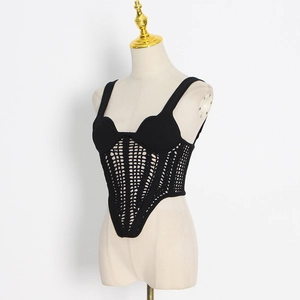 Detailed view of black knitted corset top featuring hollow-out patterns and pointed hem