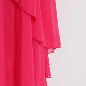Détail de robe en mousseline rose montrant les volants superposés et les coutures fines