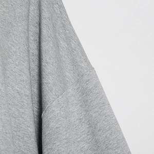 Detailed close-up of shoulder seam and grey knit fabric texture on sweatshirt