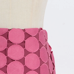 Détail d'une jupe magenta présentant des motifs circulaires brodés en relief 3D