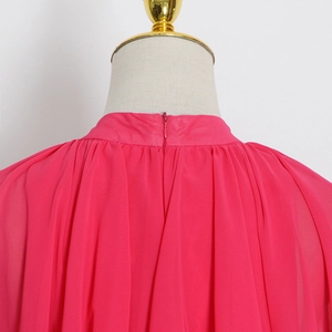 Détail de la robe en mousseline rose fuchsia montrant la fermeture éclair et le plissé