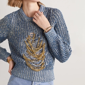 Detailed view of chunky gold chain fringes on a blue-white mixed knit sweater