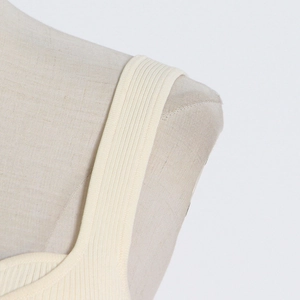 Detailed close-up of apricot ribbed knit tank top with seamless wide shoulder strap design