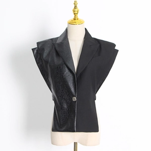 Détail du patchwork en cuir synthétique croco et épaulette sur le gilet noir