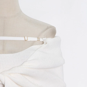 Close-up of white ribbed knit dress shoulder straps with premium gold metal adjusters