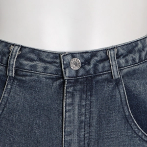 Macro view of vintage indigo denim jeans waist with metallic button and contrast stitching