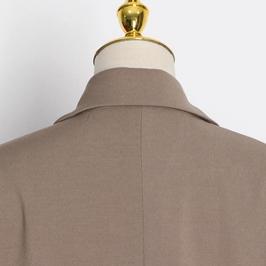 Detailed view of the back collar and shoulder seams on a khaki tailored blazer