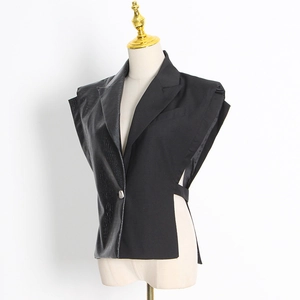 Détail du gilet asymétrique en simili cuir crocodile et tissu lisse pour femme