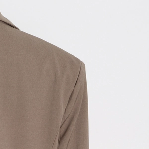 Detailed close-up of shoulder seam and collar on a brown hollow-out blazer for women