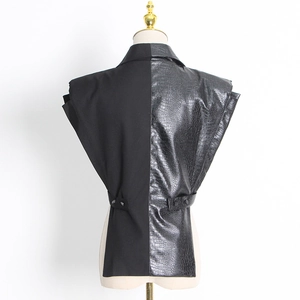 Détail de la ceinture réglable et du panneau en cuir asymétrique sur le gilet noir