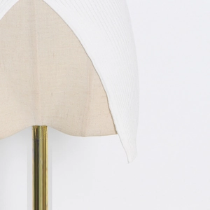 Detail of ribbed knit white top featuring asymmetric cross hem design and fabric texture
