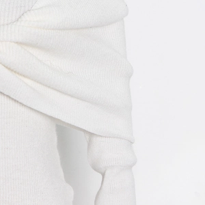Detail view of white ribbed knit fabric showing soft texture and twisted shoulder design
