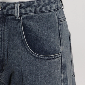 Close-up of waistband loops and pocket stitching on washed blue denim wide-leg jeans