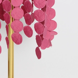 Vue détaillée de cercles en velours côtelé magenta avec franges et ferrures dorées