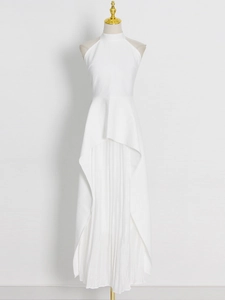 Detail view of white halter sleeveless dress with layered asymmetrical pleated skirt hemline