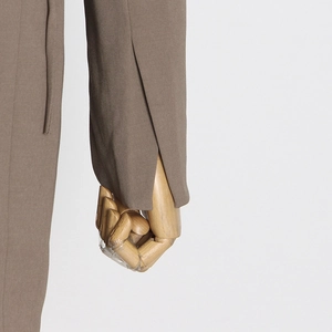 Close-up of stylish blazer sleeve featuring unique split cuff and woven fabric texture