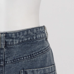 Detailed close-up of high-waisted washed gray denim jeans with reinforced double stitching