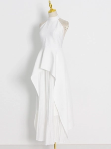 Detail of white halter neck dress with pleated chiffon lining and asymmetric layered hem