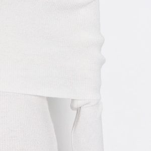 Close-up of white ribbed knit fabric texture showing thick material and fine seams