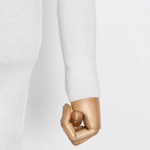 Detailed macro view of white knit sleeve with ribbed cuff on a mannequin hand