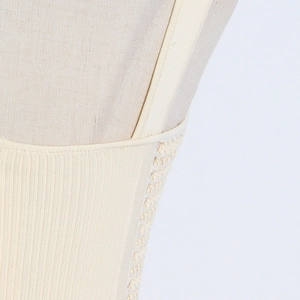 Macro detail of the vertical rib knit texture and breathable mesh on a cream corset top