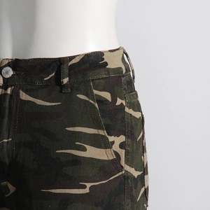 Detailed macro view of the camouflage pattern fabric and silver jeans metal button