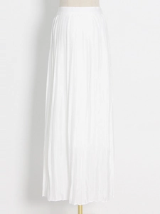 Detailed close-up of vertical pleated texture on a white high-waist A-line maxi skirt