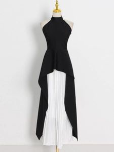 Detail of elegant black halter top with irregular hem and white pleated skirt layers