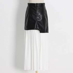 Detail of high waist asymmetric black PU leather layered over white pleated long skirt