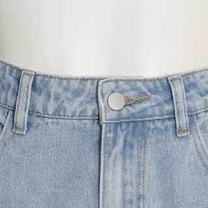 Detail shot of light blue denim waistline with silver metal button and belt loops
