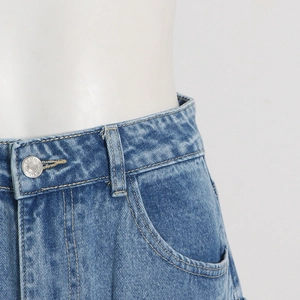 Close-up of waist area on wash blue cargo jeans with metal button and reinforced stitching