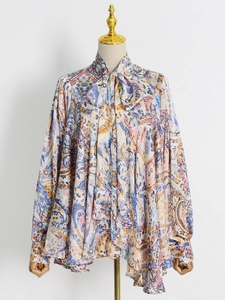 Detail of paisley print blouse with neck tie and ruffled front on a mannequin