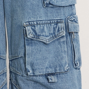 Macro shot of stone wash light blue denim cargo pants showing multi-pocket stitching details