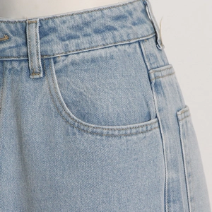 Close-up of light blue high waist denim jeans showing pocket stitching and twill texture