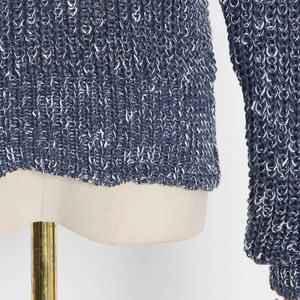 Close-up of blue and white knit sweater showing texture and cuff detail on a mannequin