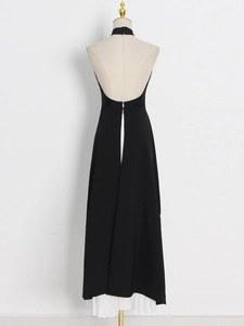 Detail of elegant backless halter dress featuring a chic black fabric with white pleated lining