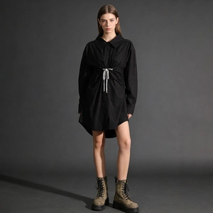Détail d'une robe chemise noire à manches longues avec cordon de serrage argenté à la taille
